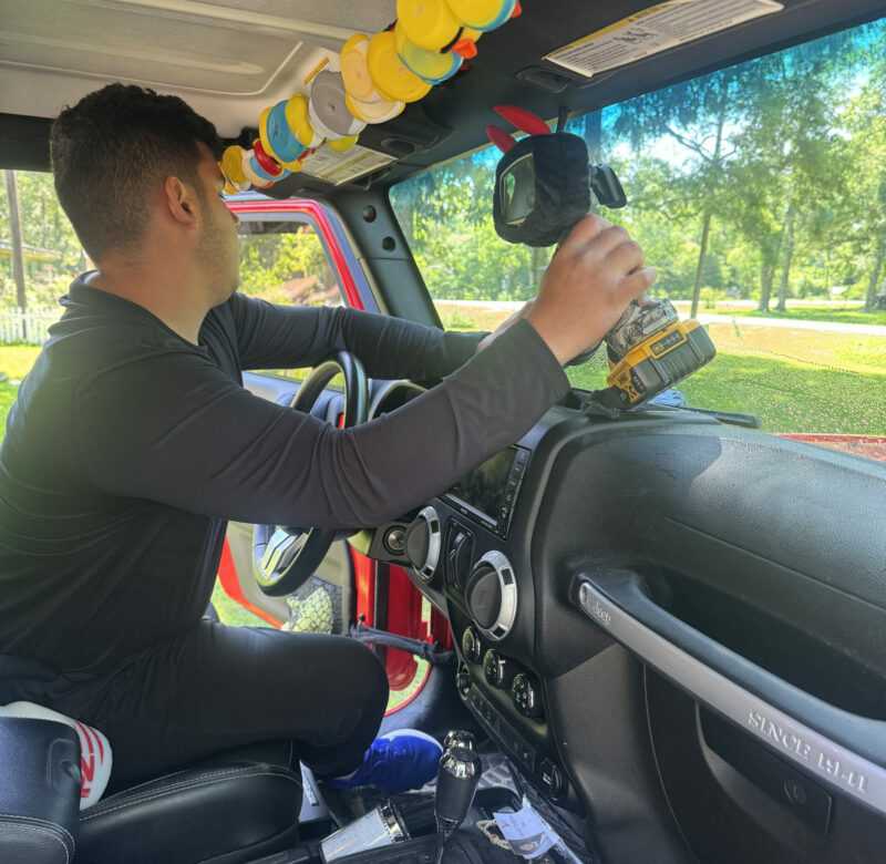 Technician working on a windshield replacement at a customer location